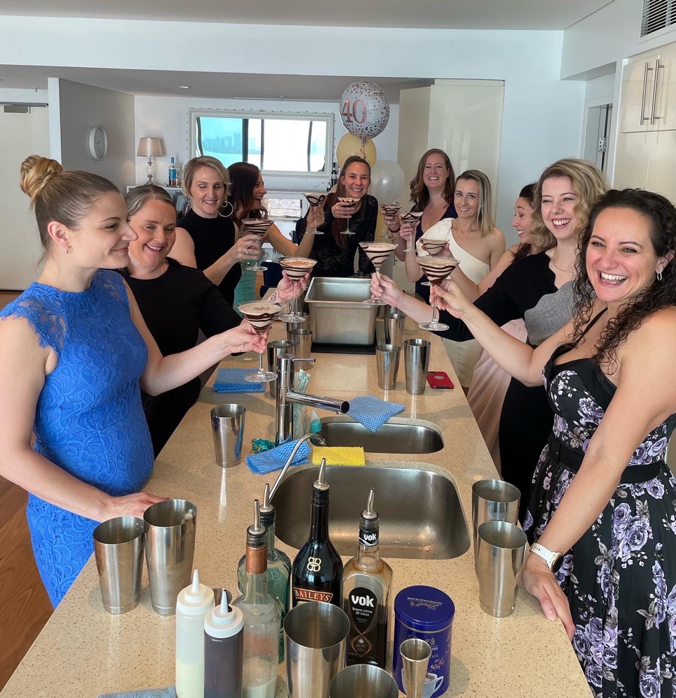 Guests making cocktails along a kitchen bench
