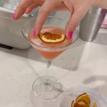 A guest adding a dried orange garnish to a cocktail